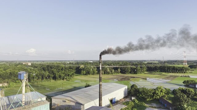 Drone footage of a large rice processing facility in Khajanagar, Kushtia, surrounded by agricultural land, green vegetation, and power infrastructure, with visible smoke rising