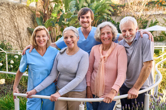 Group Of Senior Patients With Physiotherapists Smiling Outdoors In Rehab Center For Rehabilitation And Recovery After Injury Or Surgery
