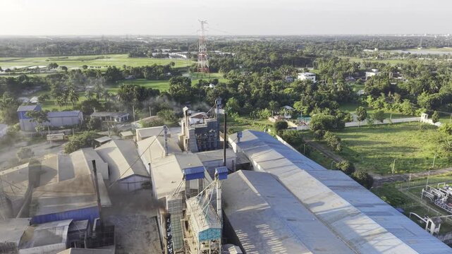 Drone footage captures a large plume of industrial smoke spreading across green agricultural land and nearby rural homes in Bangladesh, highlighting air pollution 