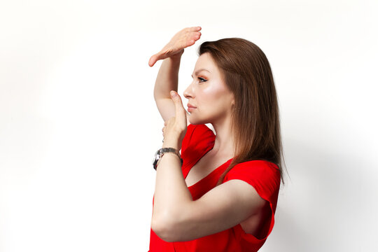 Profile portrait of young girl in red dress showing frame gesture isolated on white background.