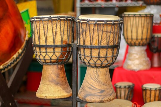 Pair of traditional wooden djembe drums on display at a music shop. 