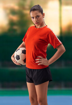 A CONFIDENT WOMAN FOOTBALL PLAYER STANDING IN FRONT OF CAMERA