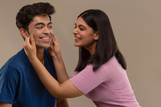 AN ELDER SISTER HAPPILY TEASING YOUNGER BROTHER