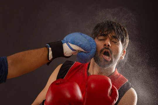 A BOXER BEING PUNCHED DURING A BOXING MATCH