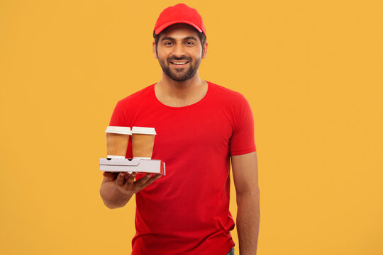 A CHEERFUL DELIVERY GUY STANDING WITH PACKED FOOD