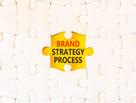 Brand strategy process words symbol. Concept words Brand strategy process on beautiful white puzzle. Beautiful yellow background. Business and brand strategy process concept. Copy space.