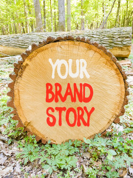 Branding and your brand story symbol. Concept words Your brand story on beautiful wooden circle. Beautiful green forest background. Business branding your brand story concept. Copy space.