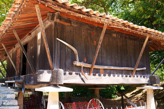 Traditional horreo (raised granary) with a vintage wooden plow mounted on wall. Museum of the Asturian People (Museo del Pueblo de Asturias) in Gijon, Spain