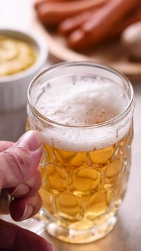 Serving beer at Oktoberfest table with sausages and mustard