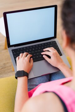 Hispanic Person typing on a laptop indoors