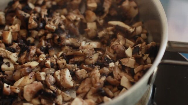 Frying chopped mushrooms in a pan on the stove close up