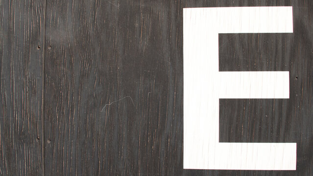 The letter &lsquo;E' written on the wall in a worn black font with white stripes