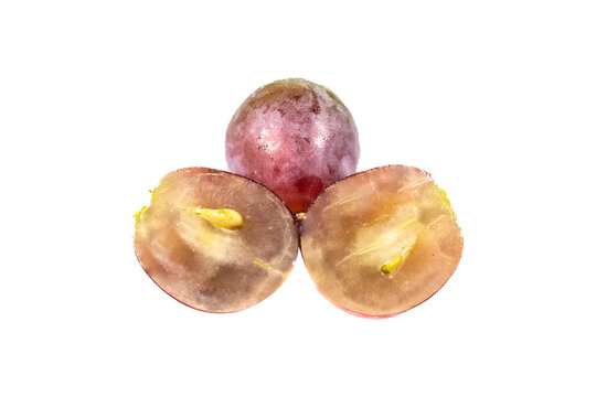One whole red grape and two sliced grape halves, showing translucent flesh, seeds, and purple skin against a white background