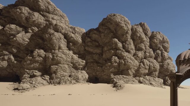 Rocky structures rise in the background with sand in the foreground. The sky is clear and blue. Sunlight illuminates the scene creating sharp contrasts.