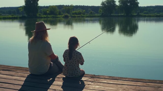 Happy mother and daughter enjoying a relaxing fishing trip 