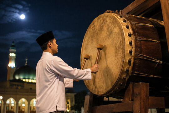 Young Muslim Man Hitting Large Traditional Bedug Drum Isolated on White and Transparent Background