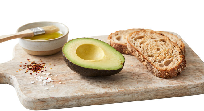 Sliced avocado with rustic bread and olive oil on board