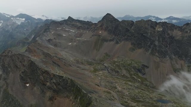 Aerial drone view above the Tyrol Alps at Timmelsjoch Pass showcasing rugged mountain ridges spectacular natural scenery on the border of Italy and Austria in Europe