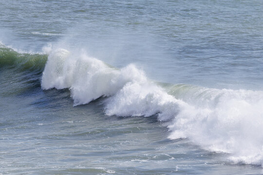 Ocean wave breaking with white foam and spray
