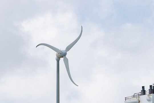 Wind turbine generating clean energy against cloudy sky