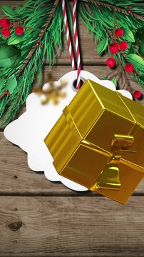 Animation of christmas tag, presents, snowflakes and decoration on wooden background