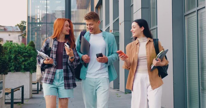 Students using smartphone and happy with man in college for social media, accepted admission and good news. Success, online university test scores and typing with people on campus for scholarship