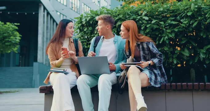Students, group of people using laptop and phone for funny post, internet meme and social media at university or campus. Happy friends in school profile picture, mobile chat or website at college or