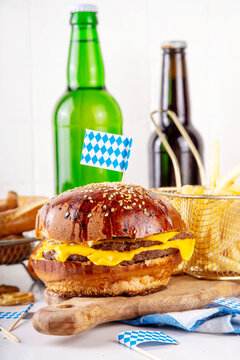 Oktoberfest Burger menu with french fries, pretzels, beer bottles. Tasty cheese hamburger in pretzel bun, with french fries, bavarian beer snacks, with checkered tablecloth and Oktoberfest decor