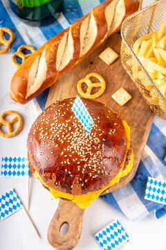 Oktoberfest Burger menu with french fries, pretzels, beer bottles. Tasty cheese hamburger in pretzel bun, with french fries, bavarian beer snacks, with checkered tablecloth and Oktoberfest decor