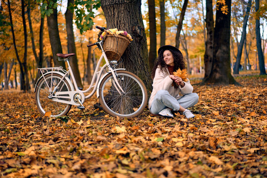 Woman with bicycle in autumn forest.