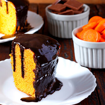 Brazilian carrot cake dessert with chocolate on a white plate, with other slices included in the composition.