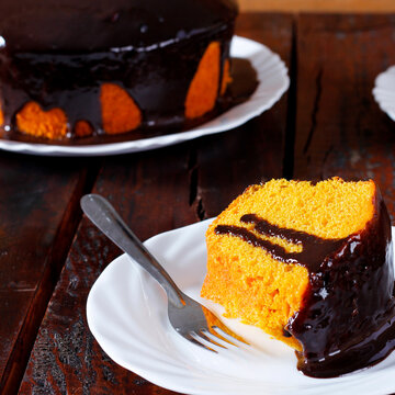 Brazilian carrot cake dessert with chocolate on a white plate, with other slices included in the composition.