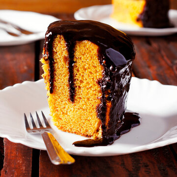 Slice of carrot cake with chocolate, accompanied by other portions on white plates.