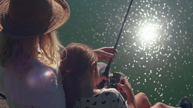 Family fishing adventure with mother and daughter casting a spinning rod 