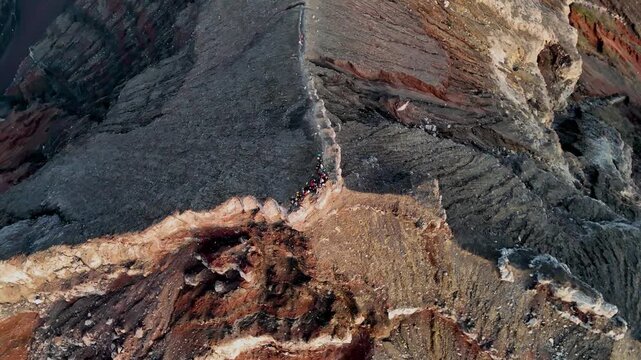 Aerial view of the rugged volcanic crater ridge of Mount Agung with dark rocky slopes in Rendang, Bali, Indonesia.