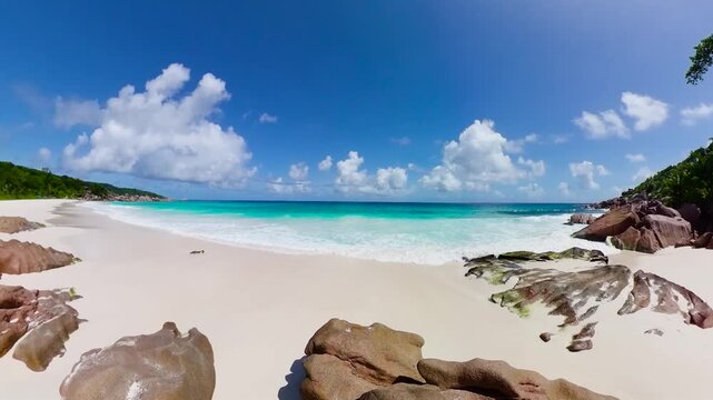 Bright white sand beach with turquoise waves crashing against smooth granite rocks. Petite Anse. Seychelles, La Digue.