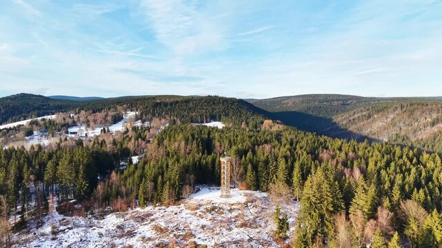 Aerial view of Rozhledna na Svetlem vrchu surrounded by snow-covered pine forests in Albrechtice v Jizerskych horach, Liberec Region, Czechia.