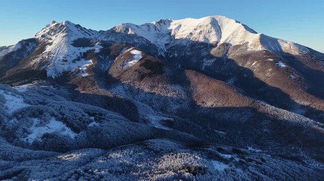 Aerial view of snow-covered peaks and forests in the Appennino Tosco-Emiliano near Cerreto Laghi, Emilia-Romagna, Italy.