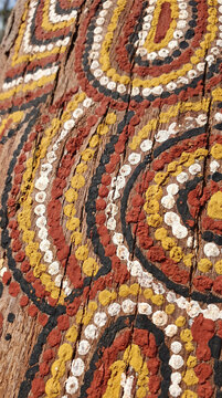 Close Up of Traditional Australian Aboriginal Dot Painting on Weathered Wood with Earth Ochres