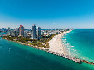 Fototapeta premium Miami Beach on blue sky. Skyline aerial view. Miami city. Tropical Miami scene. Miami district sky view. Famous oceanfront. Panoramic coastline. South beach panorama view. Summer holiday vibes.