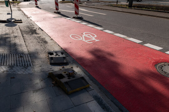 White bike sign on new red bicycle lane as sustainable city development with separated bikeway for safety in city traffic for bikers and cyclists. Sustainable transport by bike on new bike lane.