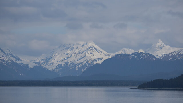 Breathtaking Alaska mountain glacier range view seen from outdoor deck of cruise ship liner sailing the Inside Passage transit with spectacular landscape wilderness scenery