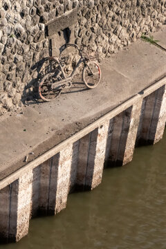 Recovering a sunken bicycle after throwing away a shared bike into a river, port or haven as environmental pollution. Muddy bike or dirty shared bike as thrown away bike sharing. Low tide brings bike.