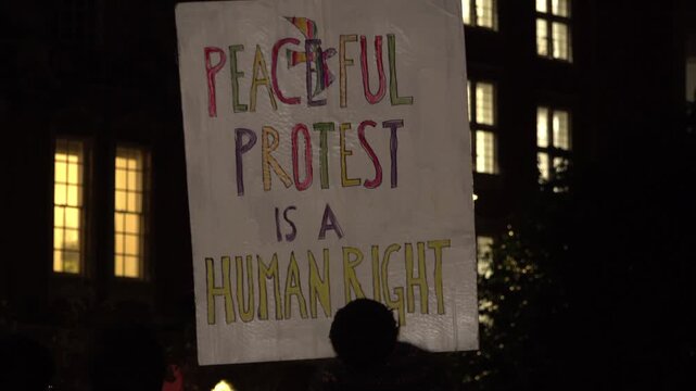 Peaceful protest sign at night during social justice demonstration.