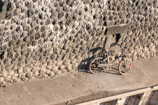 Recovering a sunken bicycle after throwing away a shared bike into a river, port or haven as environmental pollution. Muddy bike or dirty shared bike as thrown away bike sharing. Low tide brings bike.