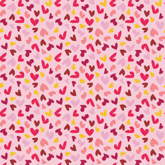 Fototapeta premium Seamless vector pattern with small red and yellow hearts on pink background