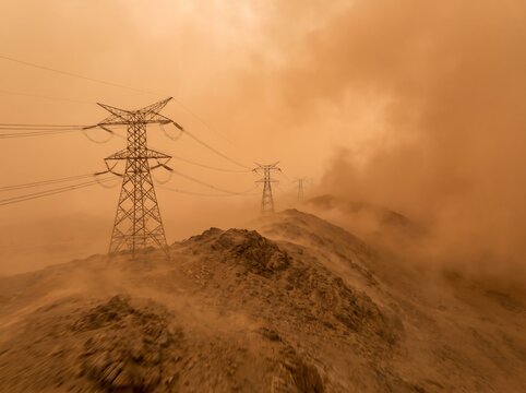 Electricity transmission tower standing on a mountain ridge during a severe dust storm or smog with electricity transmission atmosphere mountain
