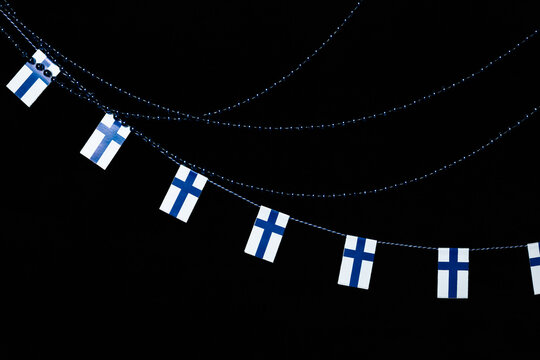 Independence Day of Finland, the Finnish flag strip in blue-and-white colors with blue string of pearls on background.