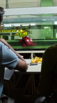 Vertical shot of young adult students, rear view, testing underwater robot in laboratory tank. Footage is perfect for STEM education and marine technology marketing