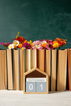 September calendar. calendar block with date 1 September, books and flowers on table against chalkboard. Back to school, Education, beginning of the school year, Knowledge Day
